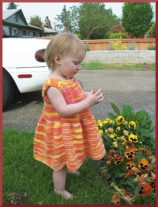A knitted sundress for a toddler.