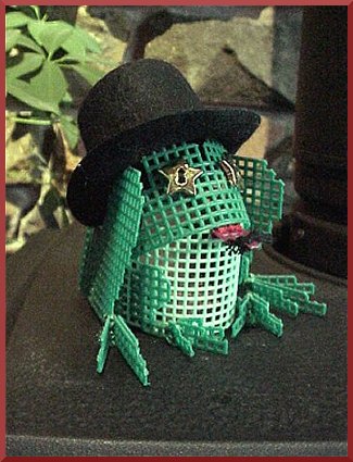 Whimisical plastic canvas frog figure.