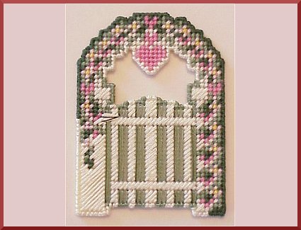 A garden gate motif stitched on plastic canvas.